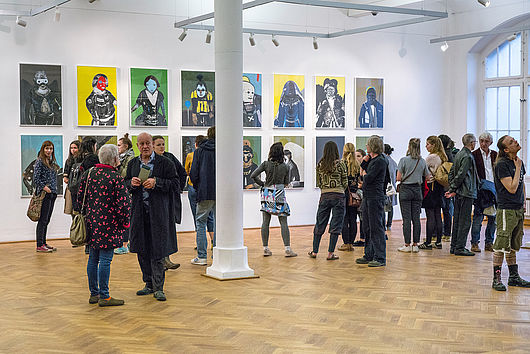 Ausstellungseröffnung, im Hintergrund Arbeiten von Prof. Thomas Rug, Foto: Etienne Dietzel